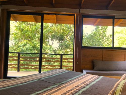 a bedroom with a bed and a view of a porch at Frondavista San Pancho in San Francisco