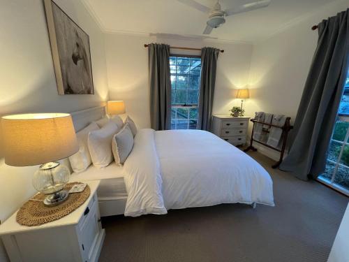 una camera con un letto bianco e una finestra di St Helen's Cottages a Clare