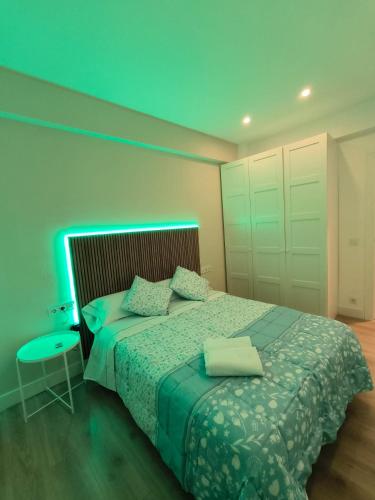 una camera da letto con un letto con una luce blu sopra di HABITACIÓN EN VIVIENDA CENTRICA BILBAo 18 a Bilbao