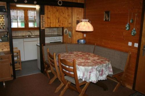 uma cozinha com mesa e cadeiras num quarto em Chalet Oase Obere Wohnung - b48609 em Susten