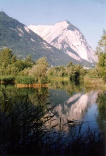 um reflexo de montanha num lago com uma montanha em Chalet Oase Obere Wohnung - b48609 em Susten