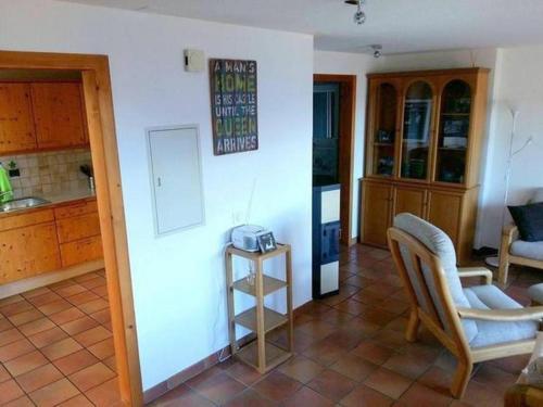 a room with a kitchen with a table and a chair at Chalet Angelika - b48583 in Albinen