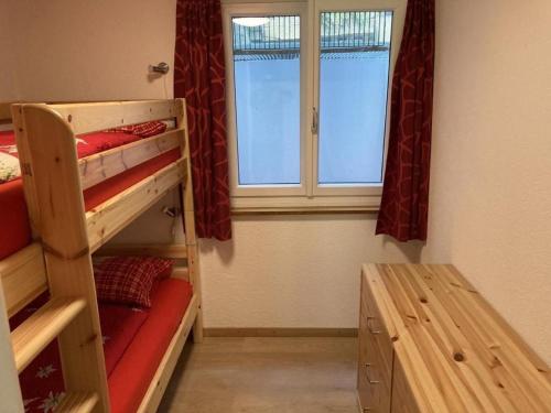 1 Schlafzimmer mit 2 Etagenbetten und einem Fenster in der Unterkunft Sonnige und saubere Ferienwohnung Selunblick im schönen Toggenburg - b48571 in Alt Sankt Johann
