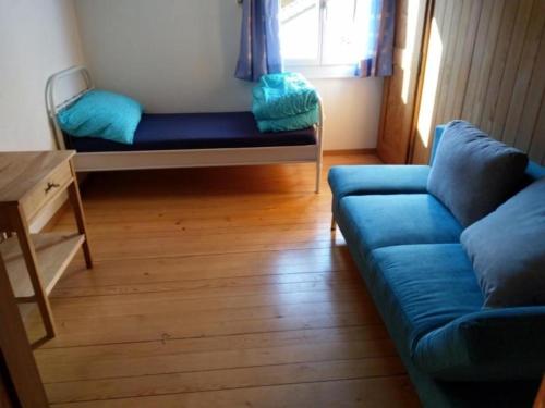 EmmeCottage - b48613 في Trubschachen: غرفة معيشة مع أريكة زرقاء وطاولة