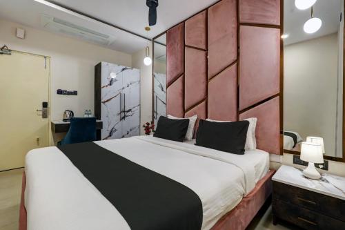 Astra Hotels & Suites - Koramangala في بانغالور: غرفة نوم بسرير كبير مع اللوح الأمامي الأحمر