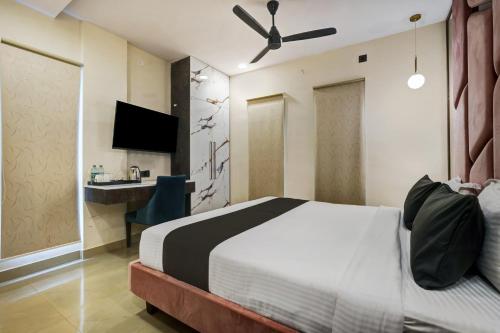 a bedroom with a bed with a ceiling fan at Astra Hotels & Suites - Koramangala in Bangalore