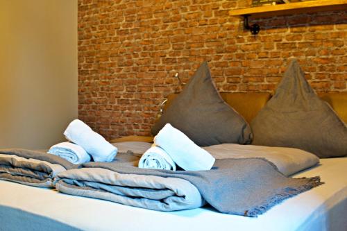 a bed with towels and pillows and a brick wall at Industrial Style 77qm mit Balkon in Herne