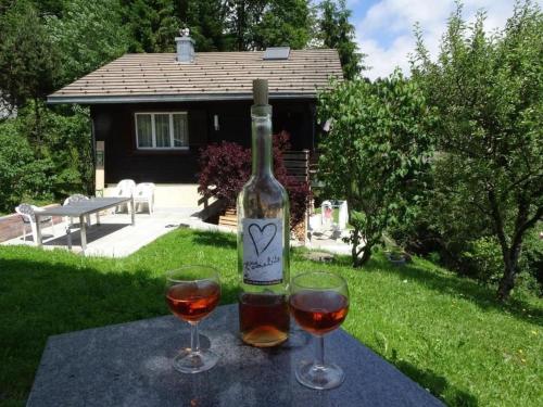 a bottle of wine and two glasses on a table at Ferienhaus Luegisland - b48622 in Giswil