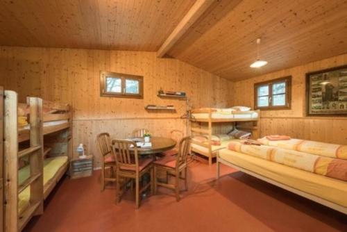 Zimmer mit Etagenbetten sowie einem Tisch und Stühlen in der Unterkunft Bauernhof - Familienzimmer - b48580 in Lungern