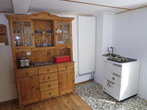 cocina con armarios de madera y nevera blanca en Ferienwohnung Langberg - b48588, en Lauerz