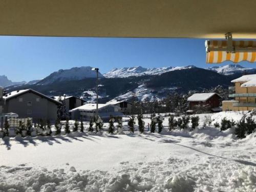 uma colina coberta de neve com árvores, edifícios e montanhas em Ferienwohnung Diala - b48608 em Lenz