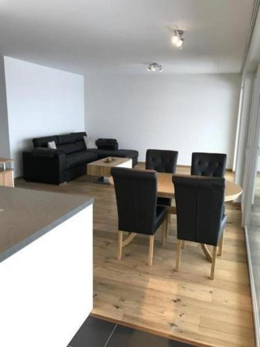 - un salon avec une table, des chaises et un canapé dans l'établissement Ferienwohnung Diala - b48608, à Lenz