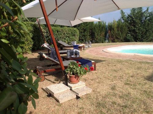 a chair and an umbrella next to a pool at B&B dell'Aviatore in San Liberato