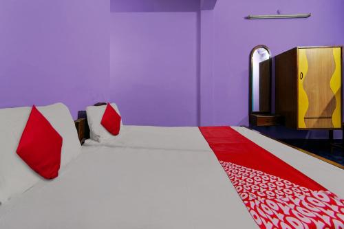 een slaapkamer met een groot bed met rode en witte lakens bij OYO Sri Sivasakthi A/C Lodge in Sivakāsi