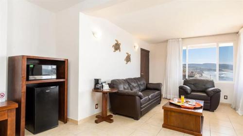 uma sala de estar com duas cadeiras de couro e uma televisão em Puerto Nuevo Baja Hotel & Villas em Rosarito