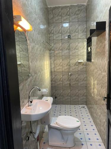 een badkamer met een toilet en een wastafel bij Guest house in Cotonou