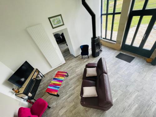 - un salon avec un canapé et une télévision dans l'établissement Gîte spacieux et lumineux dans belle dépendance avec terrasse privative, parc et chiens acceptés - FR-1-410-412, à La Flèche