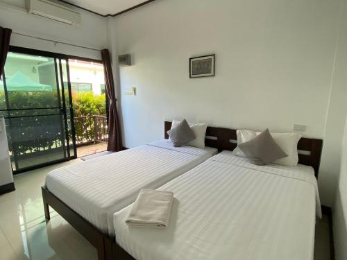 two twin beds in a room with a balcony at Thongsuk Mini Resort in Ban Nong Ban Kao