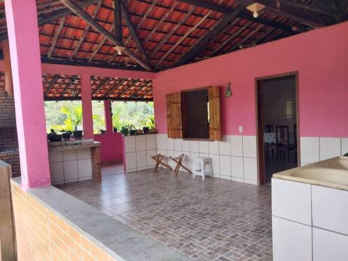 - une cuisine aux murs roses et une table dans une chambre dans l'établissement Sítio do Vicente @sitiodovicenteop, à Ouro Preto
