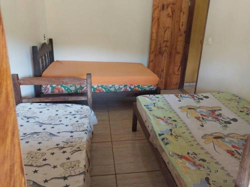 une chambre avec trois lits dans une pièce dans l'établissement Sítio do Vicente @sitiodovicenteop, à Ouro Preto