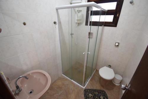 a bathroom with a shower and a toilet and a sink at CASA PERUIBE in Peruíbe