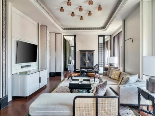 a living room with a couch and a tv at InterContinental Chiang Mai The Mae Ping in Chiang Mai