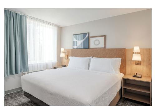 a bedroom with a large white bed and a window at Staybridge Suites Federal Way - Seattle South by IHG in Federal Way