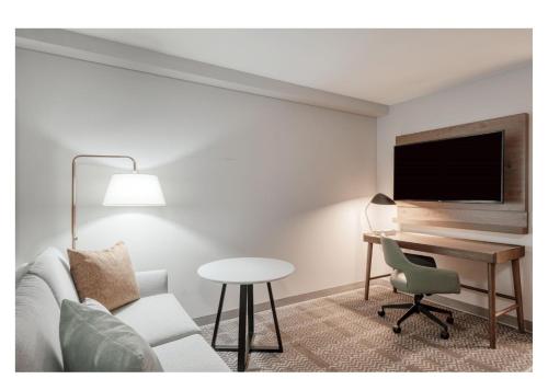 a living room with a couch and a table and a tv at Staybridge Suites Federal Way - Seattle South by IHG in Federal Way