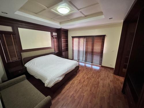 - une chambre avec un lit blanc et un canapé dans l'établissement KT Villa 963, à Bangkok