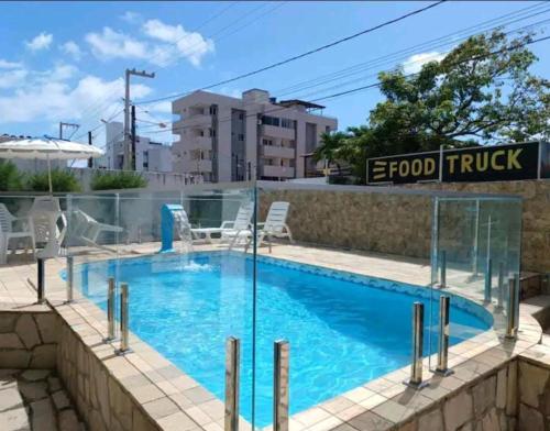 uma piscina com uma cerca de vidro à volta em Apartamento Completo Praia de Camboinha em Cabedelo
