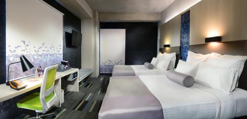a hotel room with two beds and a desk at Hotel Guadalajara Country Club by HNF in Guadalajara