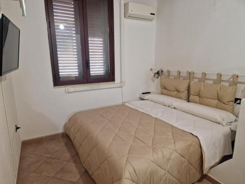 uma cama num quarto branco com uma janela em Futura House 2 Bagheria em Bagheria