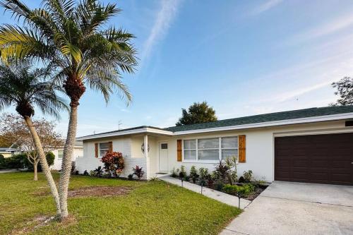a house with a palm tree and a garage at Sea Turtle Cove in Clearwater