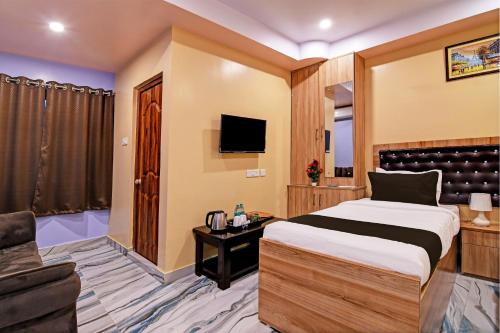 a hotel room with a bed and a tv at Super Collection O Hotel Mahal in Kolkata