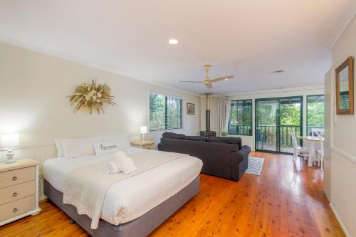 a bedroom with a large bed and a couch at The Cottages On Mount Tamborine in Mount Tamborine