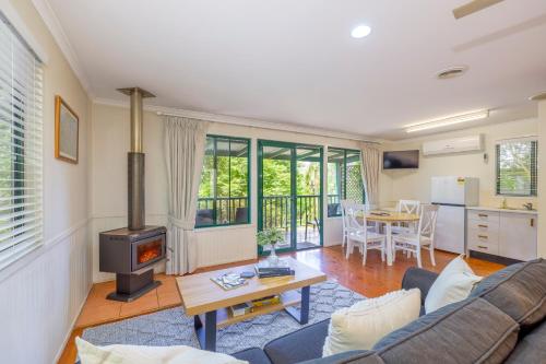 ein Wohnzimmer mit einem Sofa und einem Herd in der Unterkunft The Cottages On Mount Tamborine in Mount Tamborine