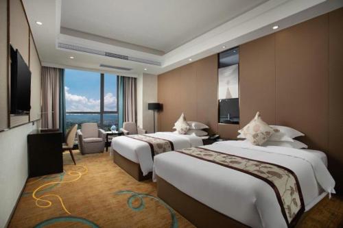 ein Hotelzimmer mit 2 Betten und einem TV in der Unterkunft Ramada by Wyndham Zhangjiajie in Zhangjiajie