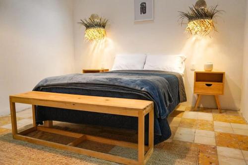 a bedroom with a bed with a table and two plants at Alberto departamento en centro Histórico Oaxaca in Oaxaca City