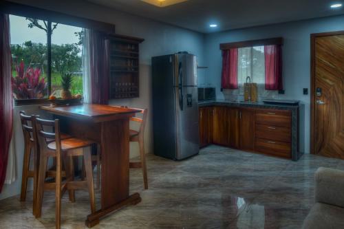 cocina con nevera y mesa de madera en Conejo's Loft, River View, Full privacy and nature, en Fortuna