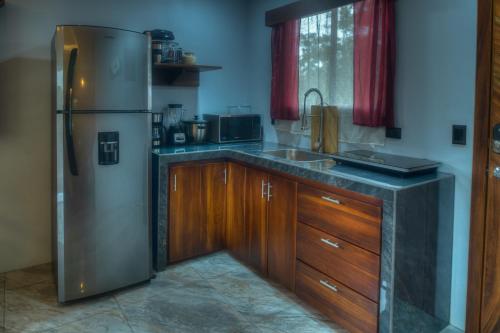 una cucina con frigorifero in acciaio inossidabile e mobili in legno di Conejo's Loft, River View, Full privacy and nature a Fortuna