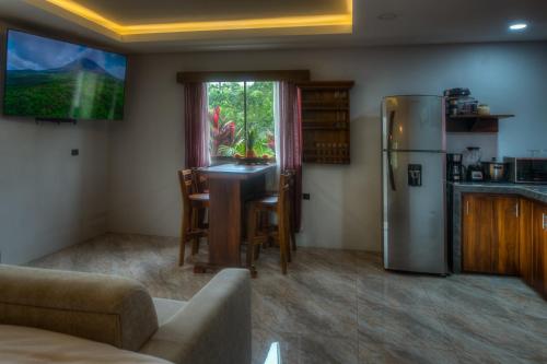 cocina con mesa y nevera en Conejo's Loft, River View, Full privacy and nature, en Fortuna