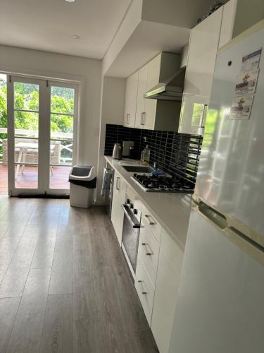 a kitchen with white cabinets and a stove top oven at 103B Mitre St Plantation House in Bathurst