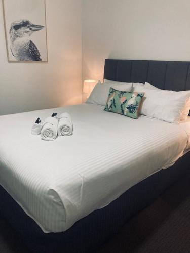 a white bed with two towels on top of it at The Platypus Accommodation & Cafe in Cudal