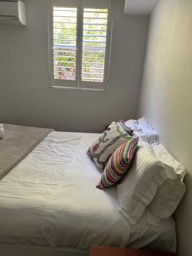 a bed with two pillows and a window in a room at 103B Mitre St Plantation House in Bathurst