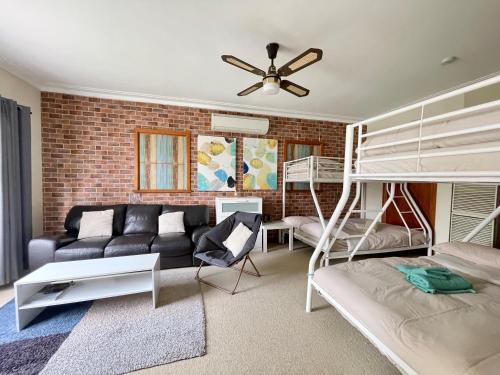 a living room with a couch and bunk beds at Sunryes Beach House in Rye