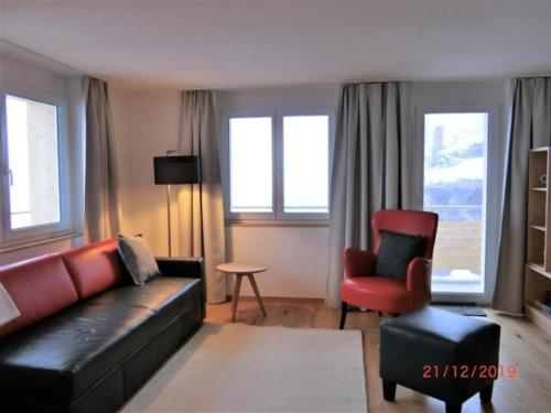 a living room with a leather couch and a chair at Chalet Raufthubel, 1 Stock - b48651 in Mürren