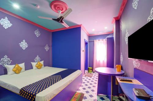 Dieses lila Zimmer verfügt über ein Bett und einen TV. in der Unterkunft OYO Hotel Divyanka Lodge in Guwahati