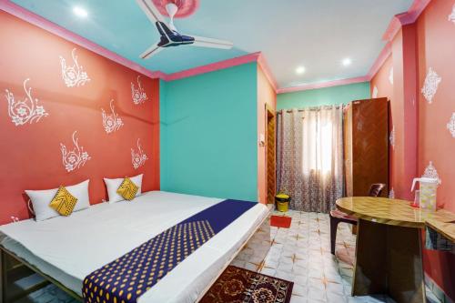 Schlafzimmer mit einem Bett und einem Tisch in der Unterkunft OYO Hotel Divyanka Lodge in Guwahati