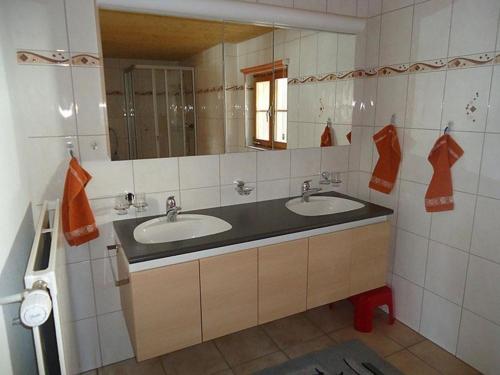 Baño con 2 lavabos y espejo en Steffelhüs 8-Bettwohnung - b48637, en Hasliberg