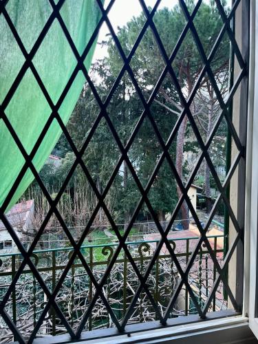 a window with a view of a garden seen through it at Albero Mago in Florence